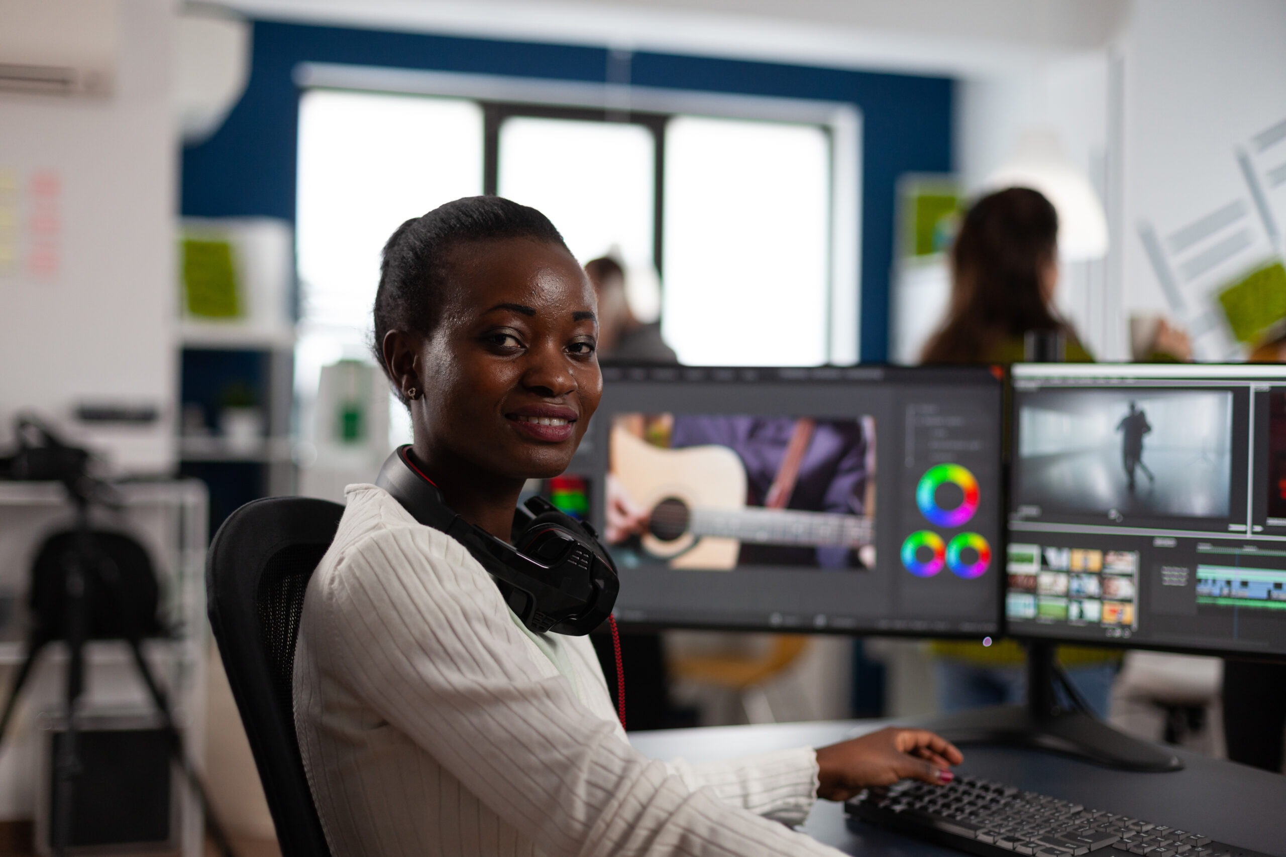 African american video editor artist looking at camera smiling editing creativity video project femme typée africaine derrière un ordinateur comme graphiste