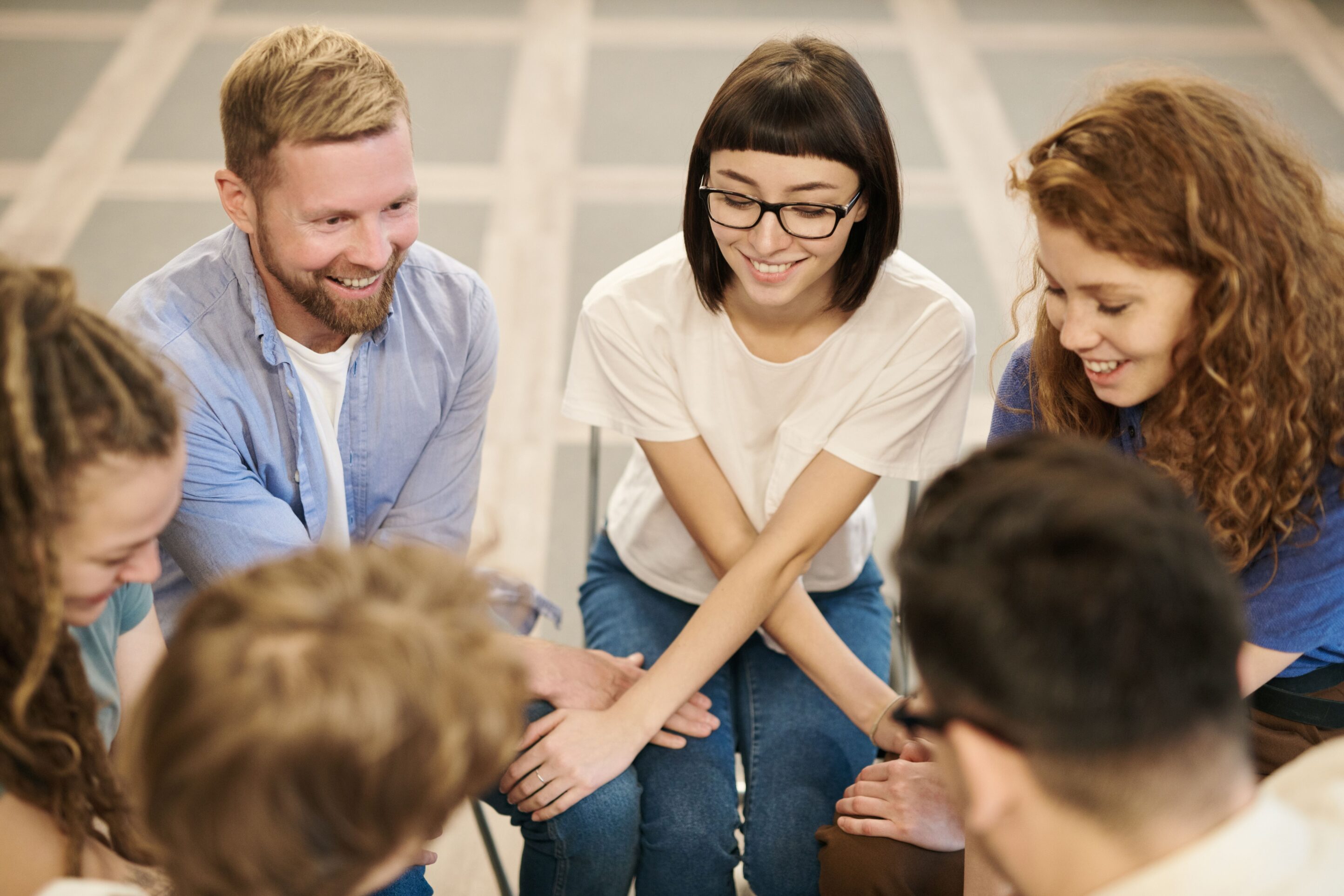 A diverse group in a supportive embrace during a meeting, symbolizing unity and connection.